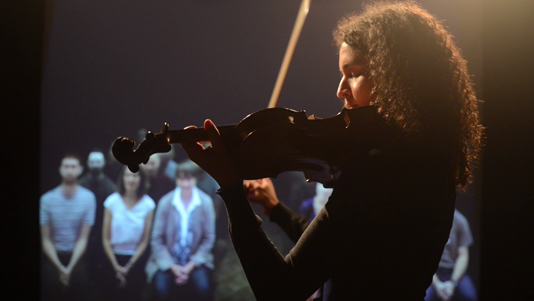 Woman playing violin to audience